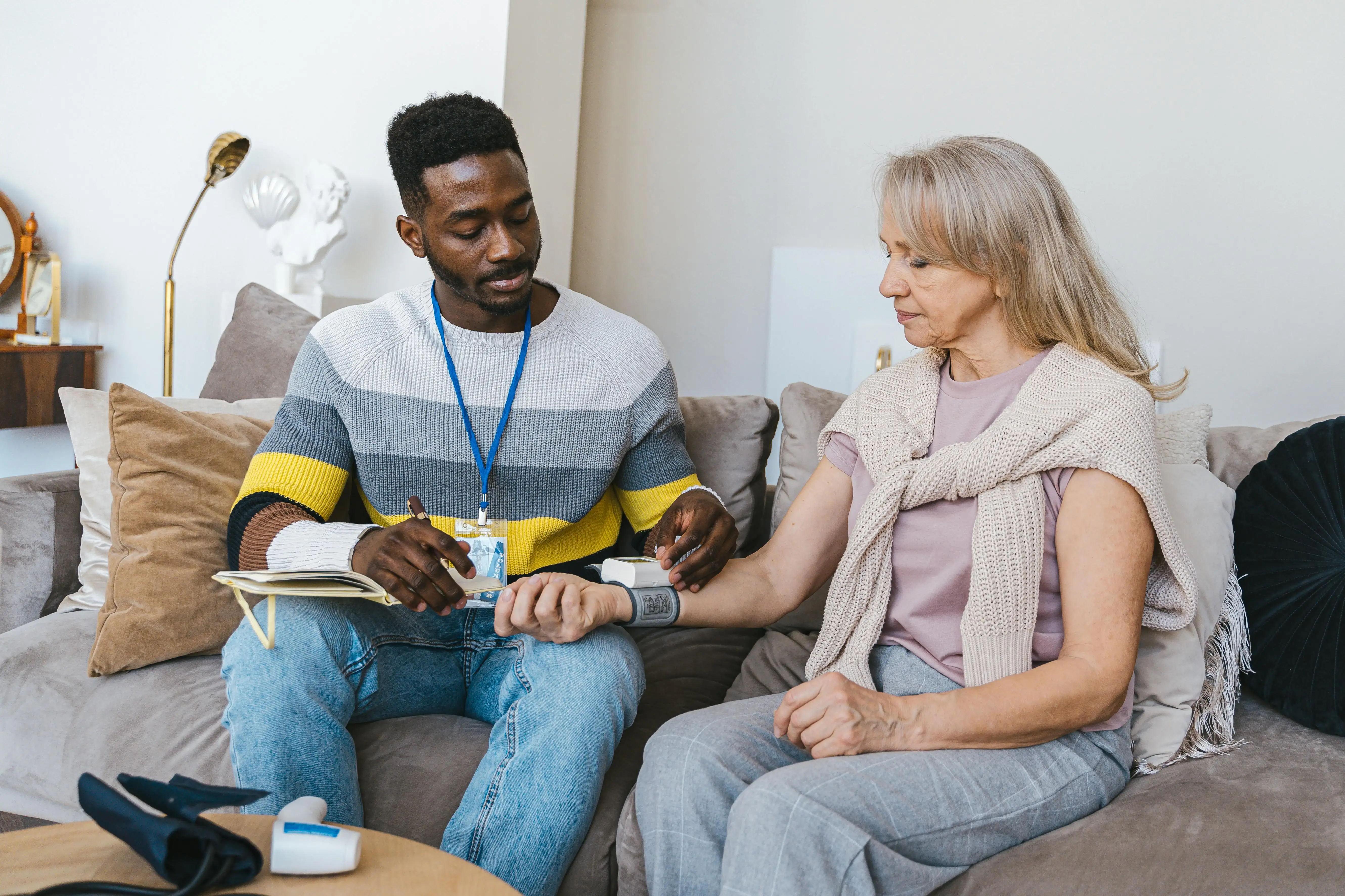 care provider measurin blood pressure of senior patient