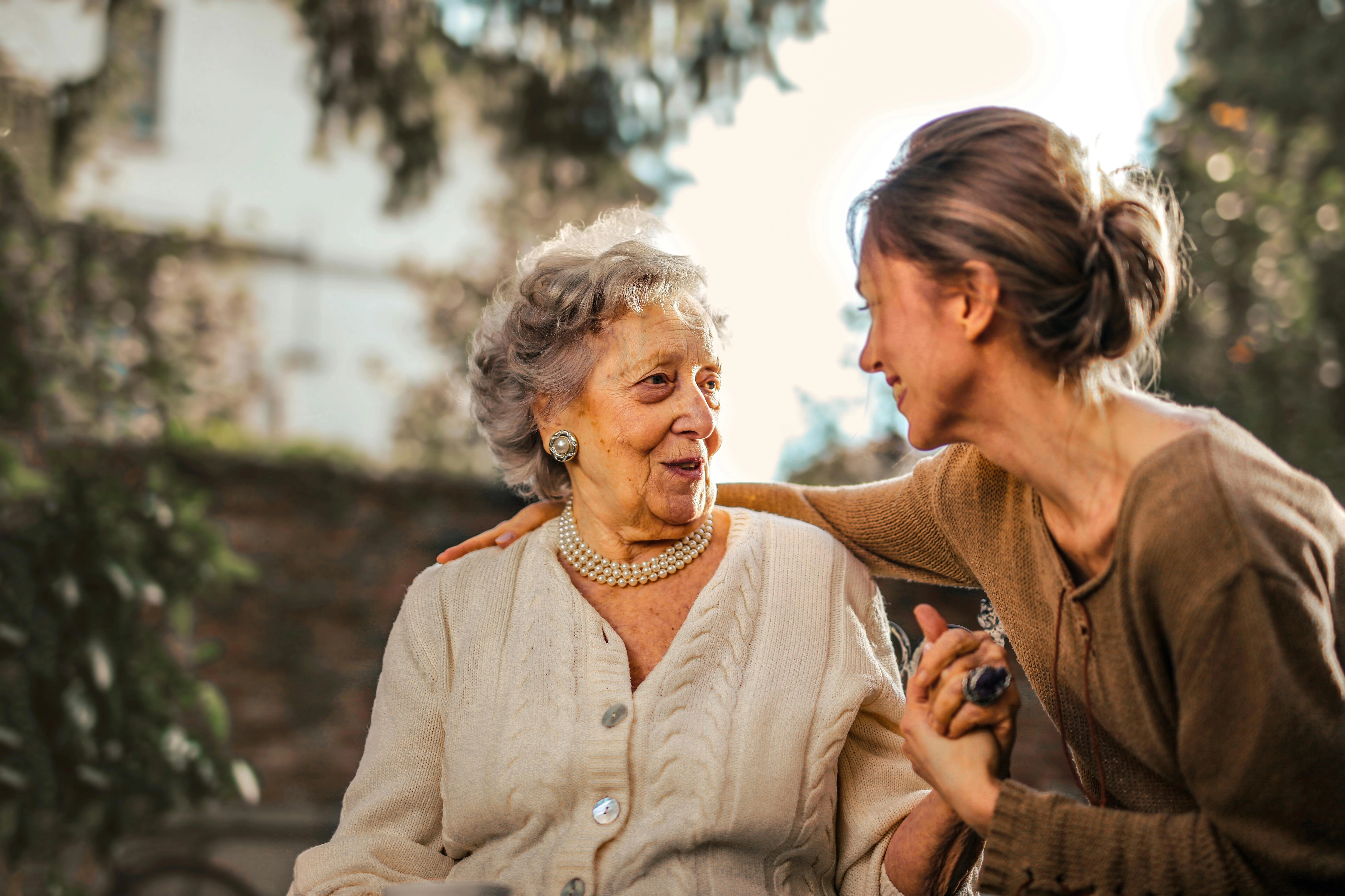 care provider talking with senior patient outside